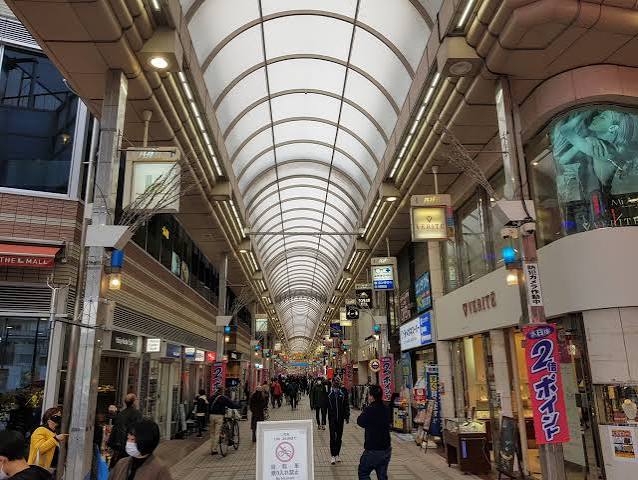 The bright neon-lit glass arched roof of the massive Musashi-Koyama Palm covered shopping arcade filled with clothing boutiques and izakayas