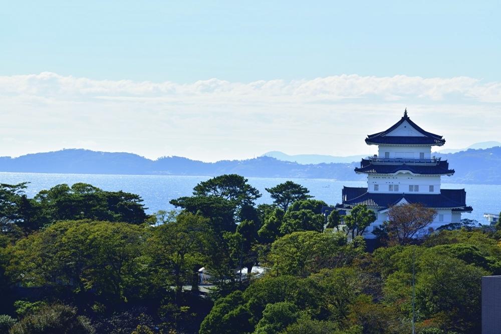 Odawara Castle's reconstructed keep rising above the coastal town with Sagami Bay in the background
