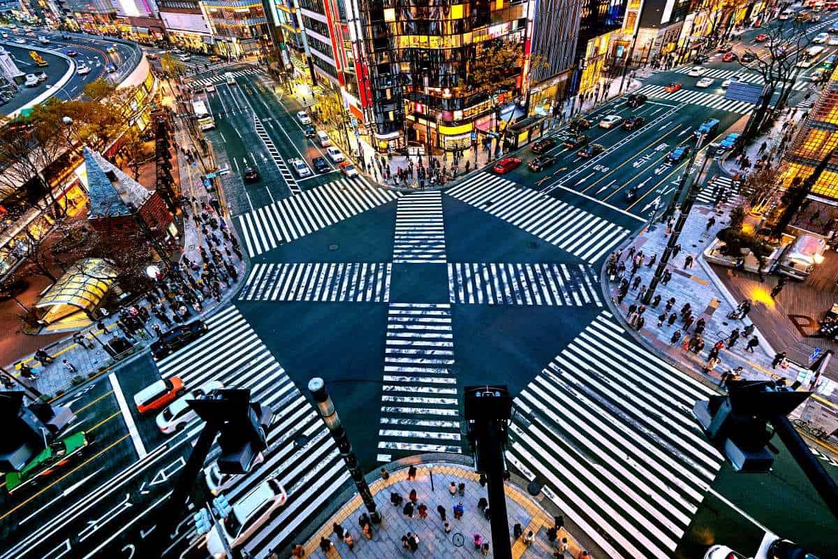 Crowds of pedestrians walking across the famous Shibuya crossing in modern downtown Tokyo