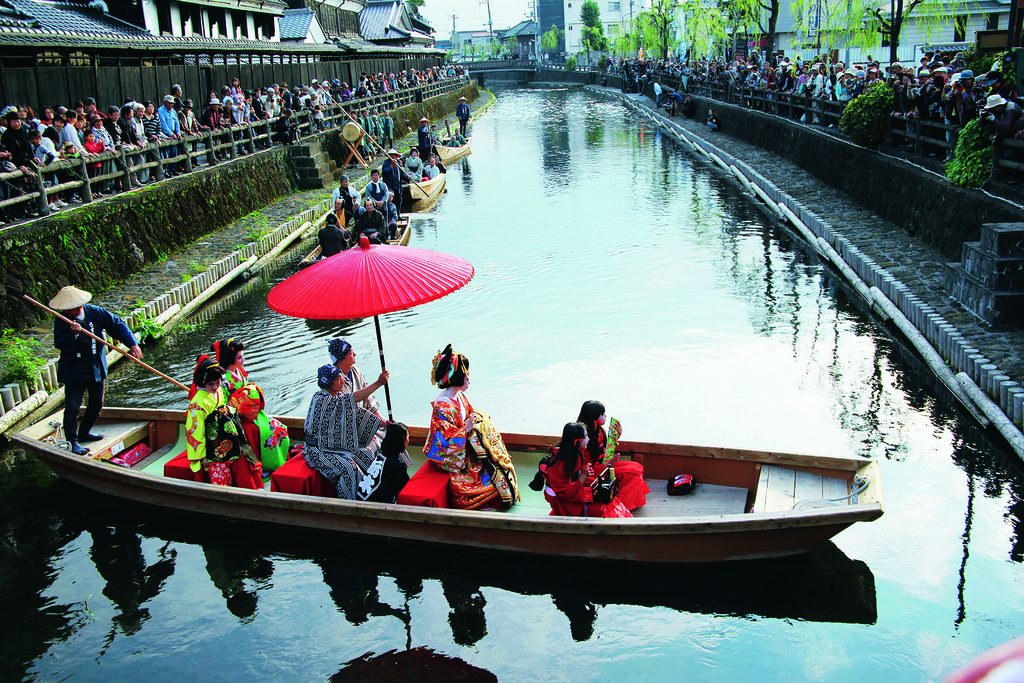 Traditional wooden boat guided by a boatman with a pole along the Uzuma River in Tochigi